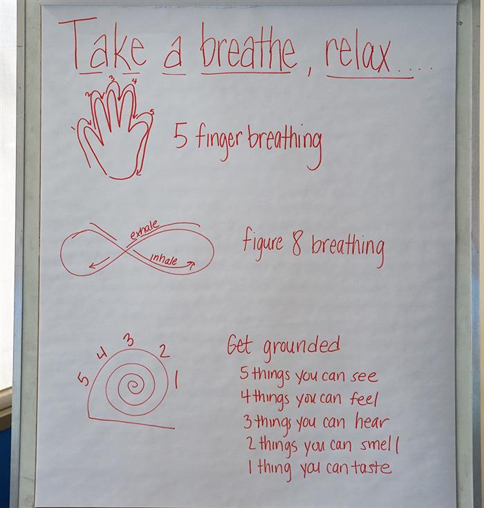 A sheet of paper that says 'take a breath, relax'